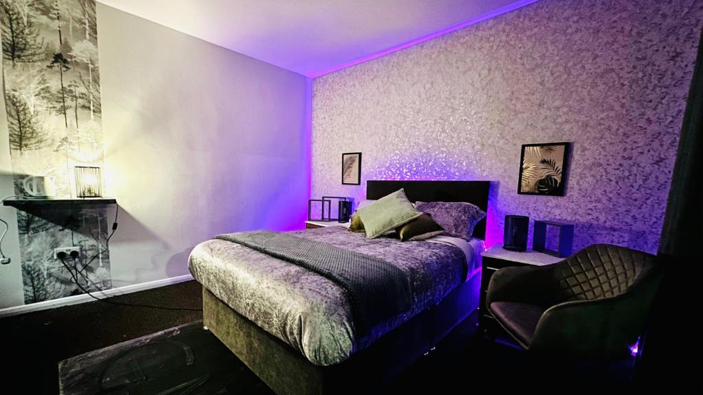 a purple bedroom with a bed and a chair at The pacific Hotel in Clacton-on-Sea