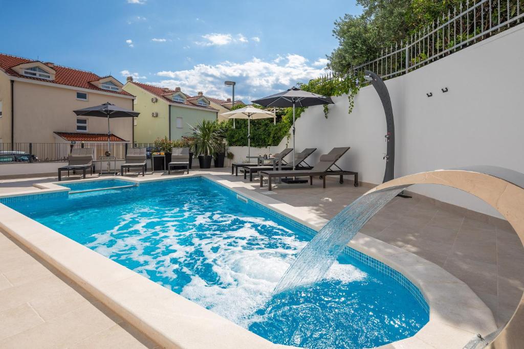 una piscina con una fuente de agua en A&D Deluxe apartments Dani with swimming pool, en Promajna