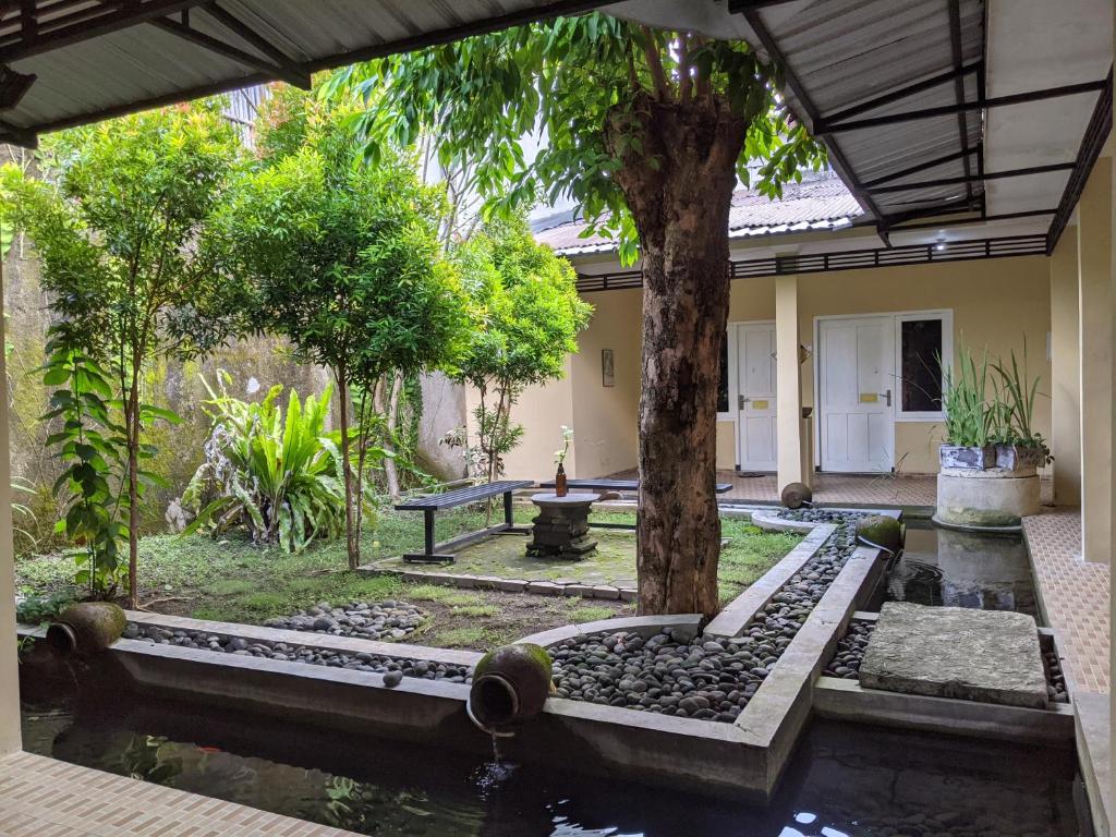 a garden with a pond and a tree at Pojok Pas in Yogyakarta