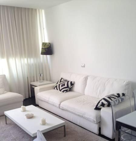 a living room with a white couch and a table at Apartamento Paco in Playa del Ingles