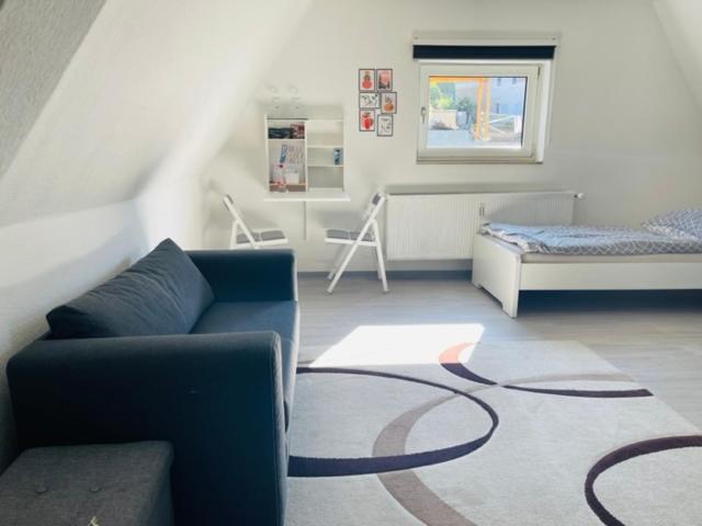 a living room with a couch and a bed at Tolle Wohnung in bester Lage von Heidenheim in Heidenheim an der Brenz