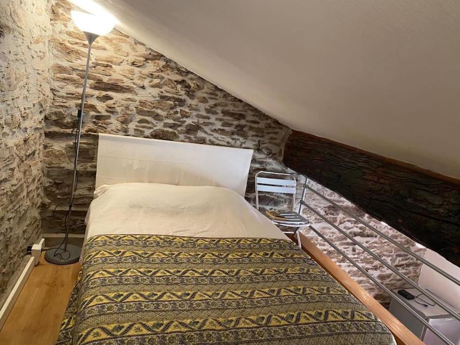 a bed in a room with a stone wall at Petite maison quartier hist in Collioure