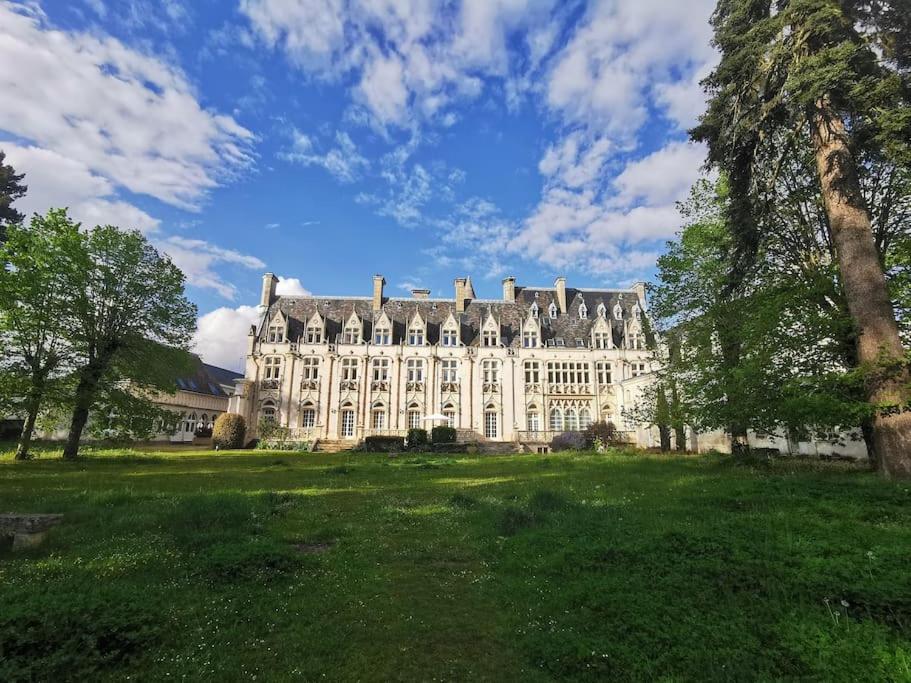 a large building with a grass field in front of it at Grand appartement dans Château Néo-gothique in Orléans