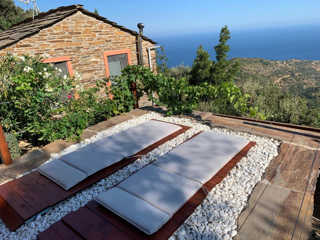einen Garten mit Felsen und ein Haus im Hintergrund in der Unterkunft Ikaria View Resort and Villa with Pool in Arethousa