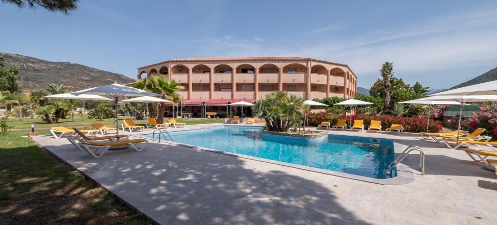 een resort met een zwembad met stoelen en parasols bij Le California Motel in Sagone