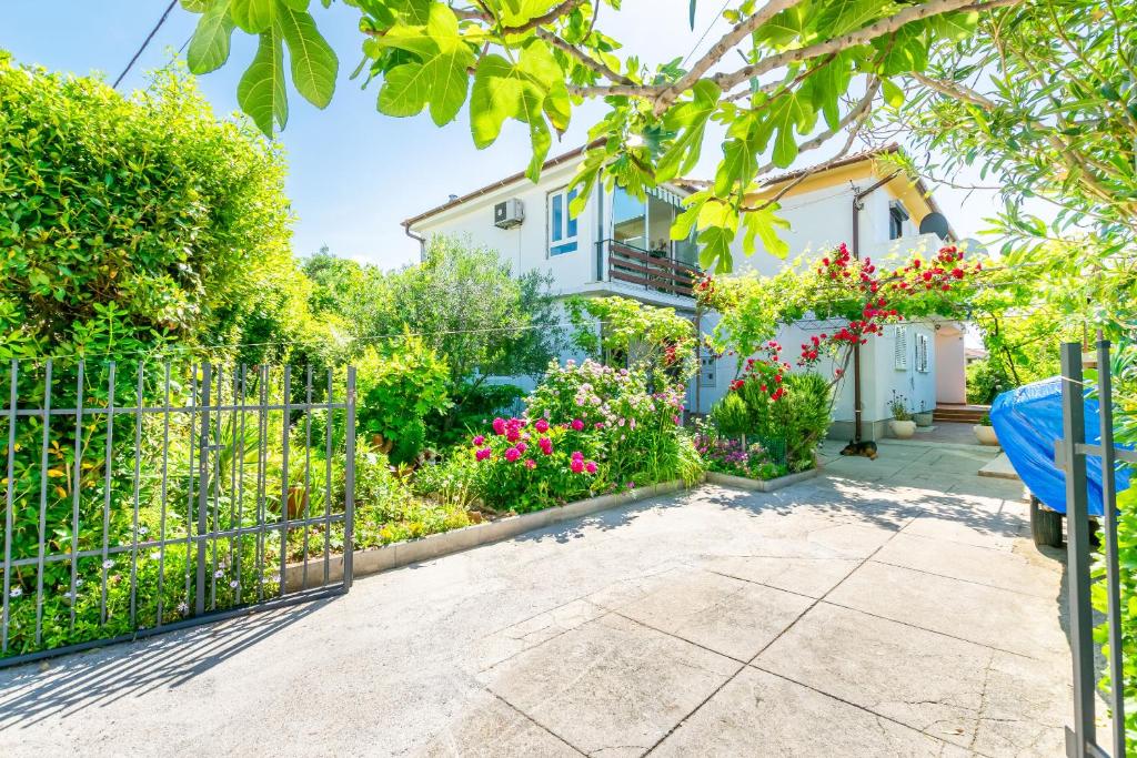 a house with a gate and a garden at Apartments Mrijana D in Barbat na Rabu