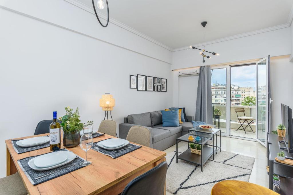un soggiorno con tavolo e divano di Zeus 2-Bedroom Apartment in Athens ad Atene