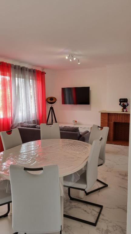 una sala da pranzo con tavolo e sedie bianche di Gîte du vignoble a Puisseguin