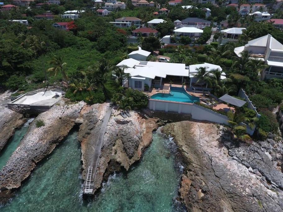 an aerial view of a house on a rocky island at Ocean front villa, pool, private ocean snorkeling in Simpson Bay