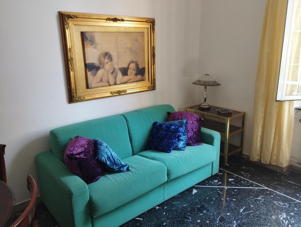 un sofá verde con almohadas en la sala de estar. en Casa Nonna Anna, en Génova