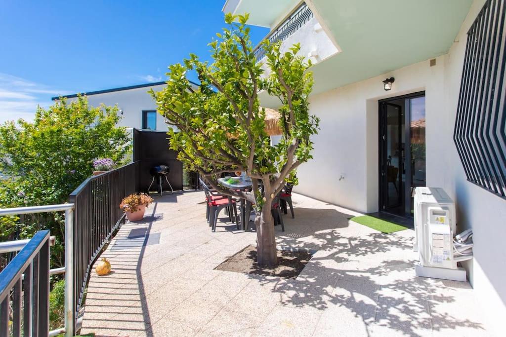 une terrasse avec un arbre, une table et des chaises dans l'établissement Echapée Belle - Vinayard view - Jacuzzi BBQ - parking, à Nice