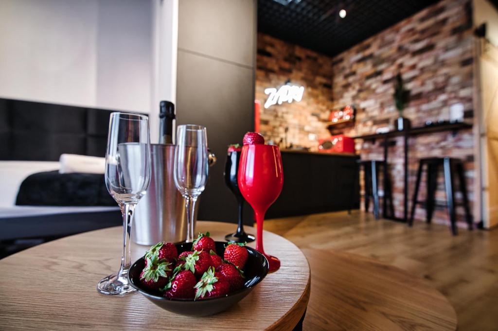 - un bol de fraises sur une table avec des verres à vin dans l'établissement Zadzior4 by Housine, à Zator