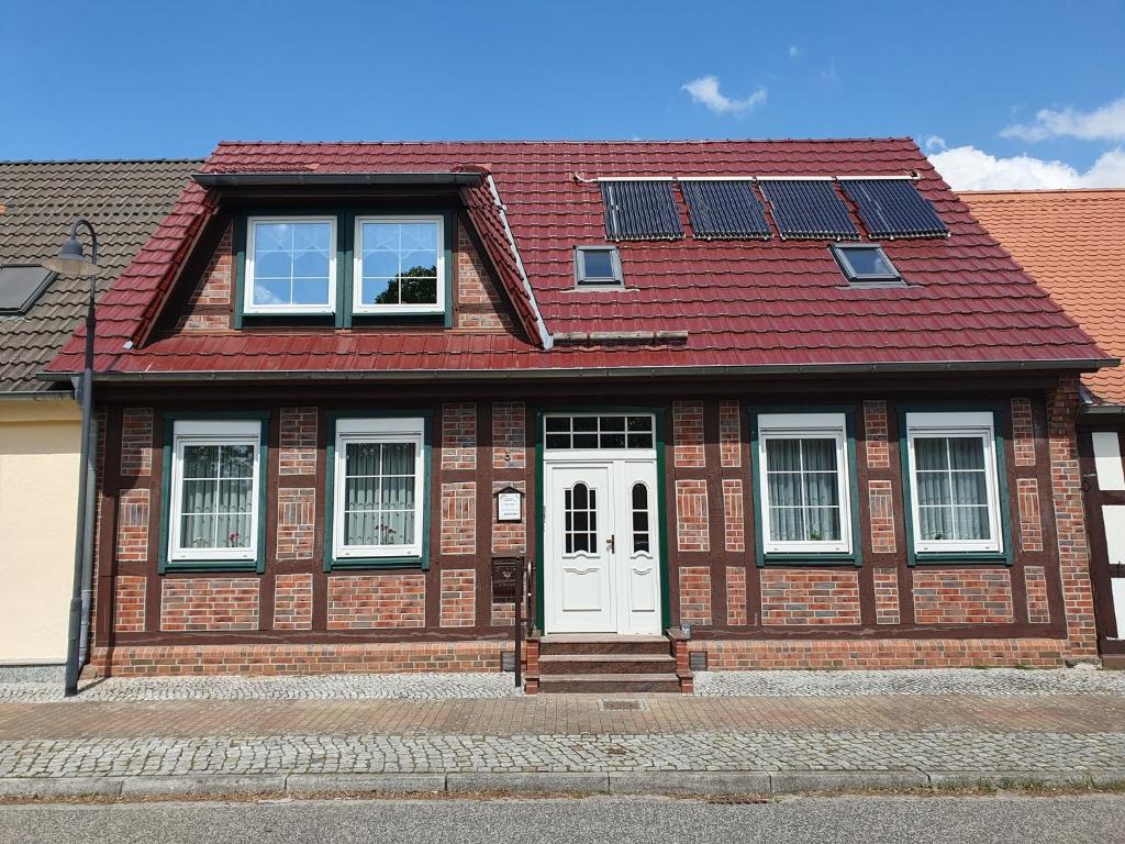 a house with a red roof and a white door at Ferienwohnung 2, oben in Bad Wilsnack