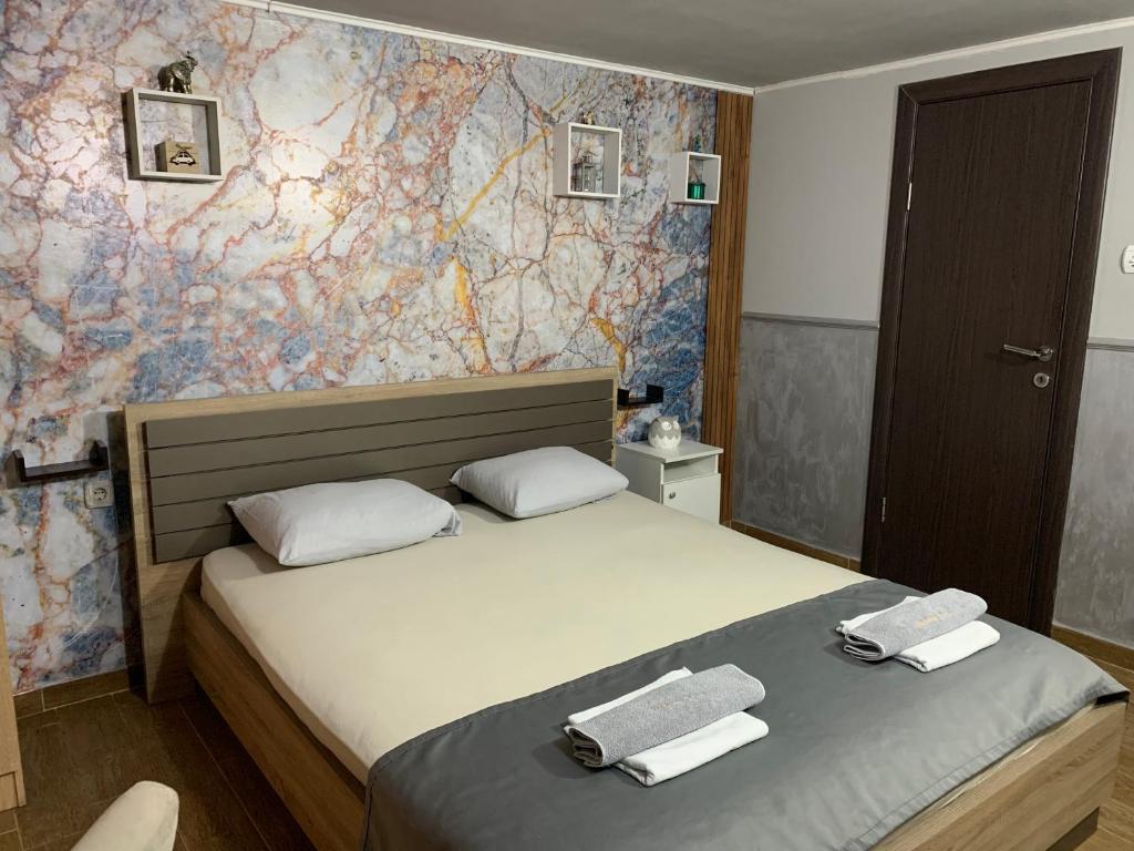 ein Schlafzimmer mit 2 Betten und Handtüchern darauf in der Unterkunft Apartman Daca in Podgorica