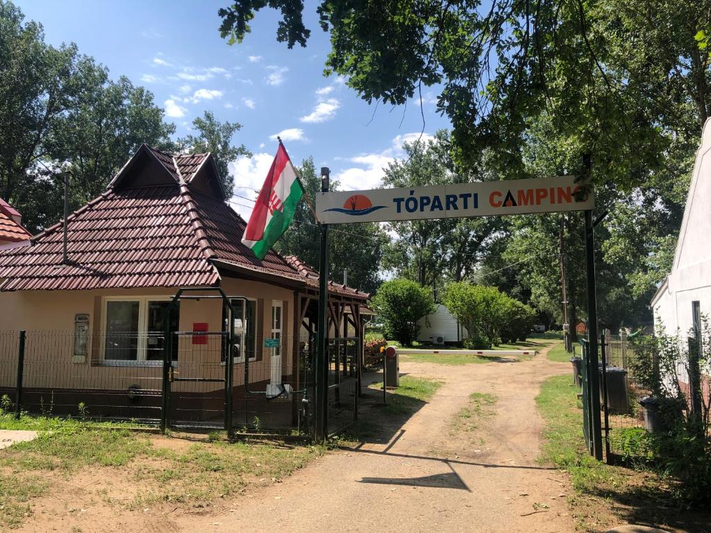 a sign in front of a house with a building at Tóparti Camping in Tiszafüred
