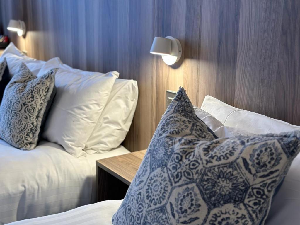 a bedroom with two beds with pillows and a table at Blarney Woollen Mills Hotel - BW Signature Collection in Blarney