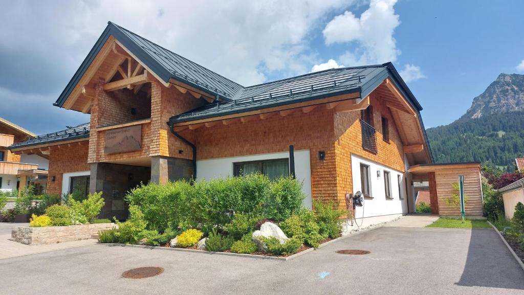 a brick house with a gambrel roof at Alpenappartement Kleiner in Tannheim