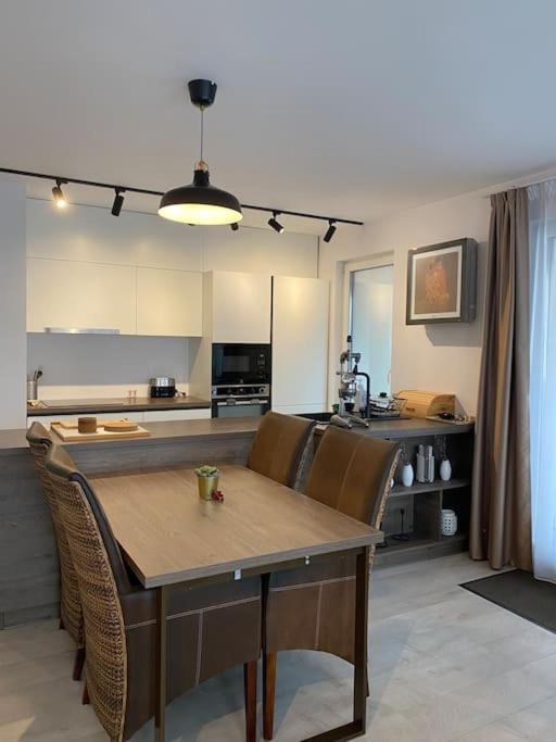 - une cuisine avec une table et des chaises dans la chambre dans l'établissement Luxurious apartment in the heart of Cluj-Napoca, à Cluj-Napoca