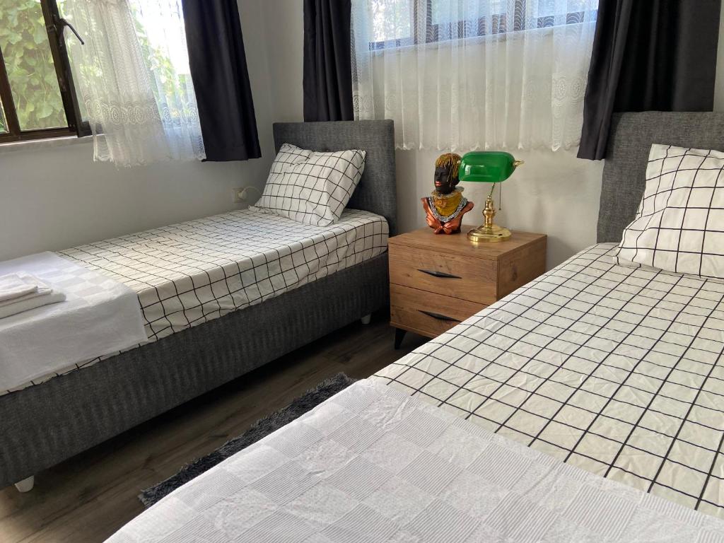 1 dormitorio con 2 camas y mesa con lámpara en Artur holiday city - double room en Gomec