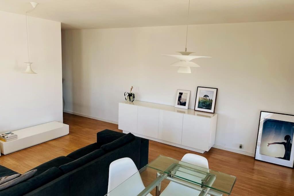 sala de estar con sofá negro y mesa de cristal en Charm Authentic Family Stay en Lisboa