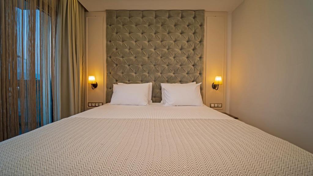 a bedroom with a large bed with two pillows at Rooms365 in Fethiye