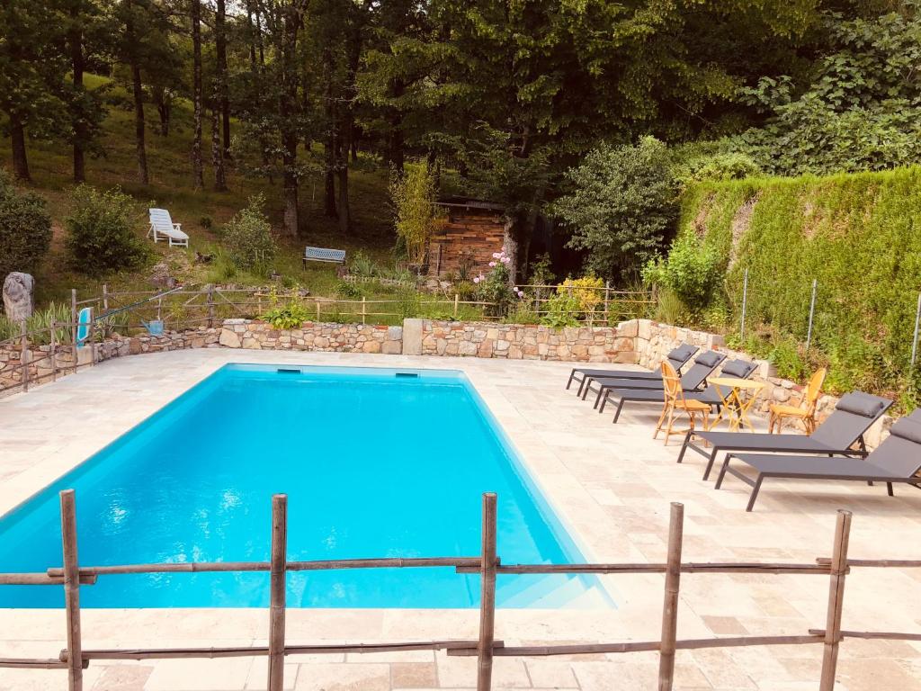 una piscina con 2 tumbonas y una mesa en Gîte le relais de la diligence, en Saint-Lazare