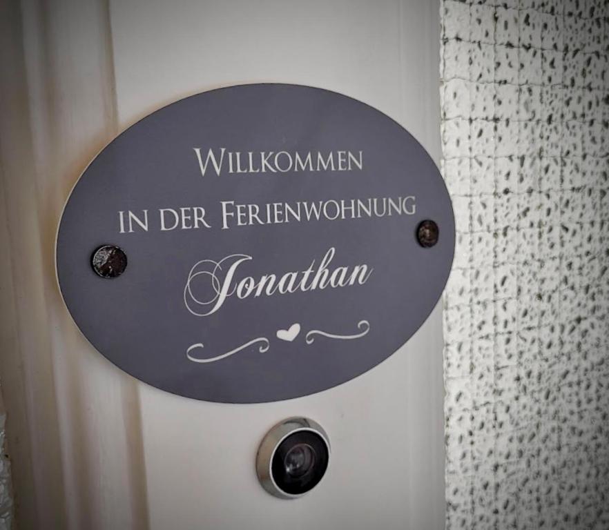 a sign on a white door with the words willkunemen in der ferning at Ferienwohnung Jonathan in Koblenz