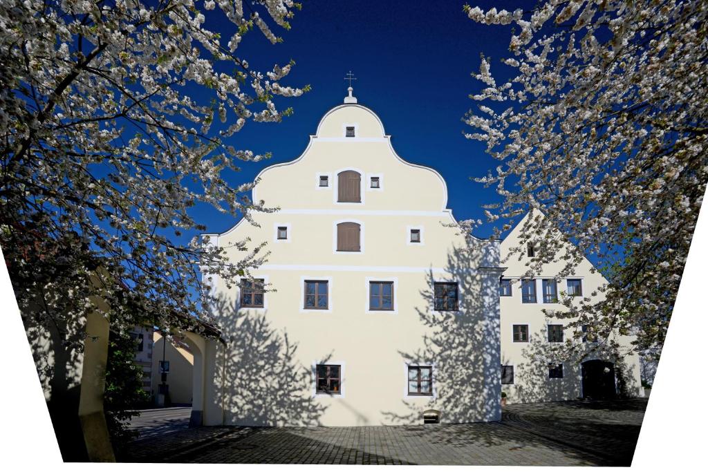 biały budynek z drzewami przed nim w obiekcie Hotel Klostergasthof w mieście Thierhaupten