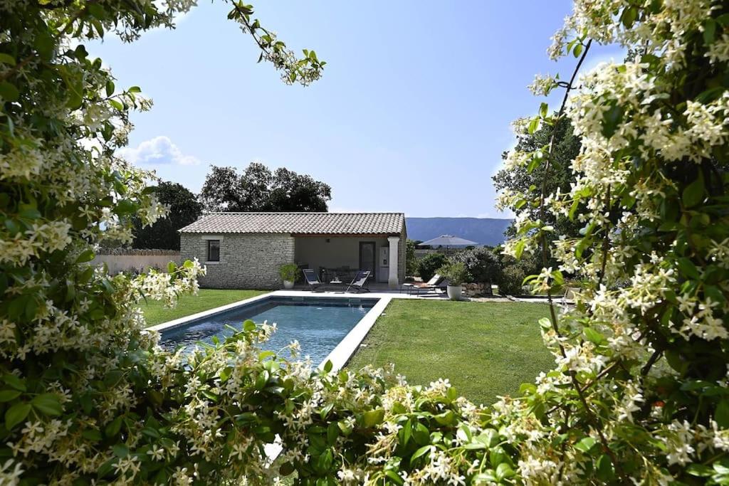 a backyard with a swimming pool and a house at Les Agapanthes de Gordes in Gordes