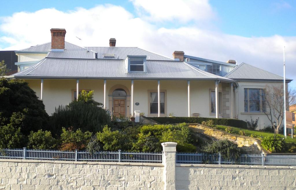 a white house with a fence in front of it at The Lodge on Elizabeth Boutique Hotel in Hobart