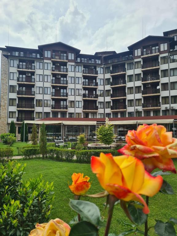 a view of a large apartment building with flowers at Апартамент и Студия "Спа Вълшебство" in Velingrad