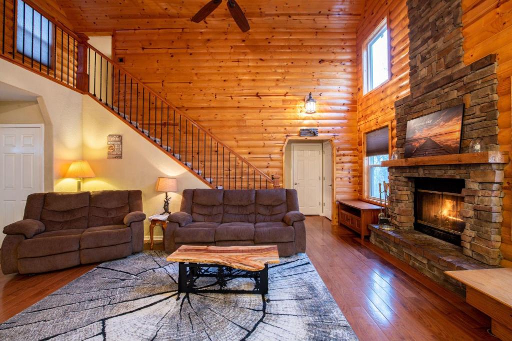 ein Wohnzimmer mit 2 Stühlen und einem Kamin in der Unterkunft Cedar Ridge 