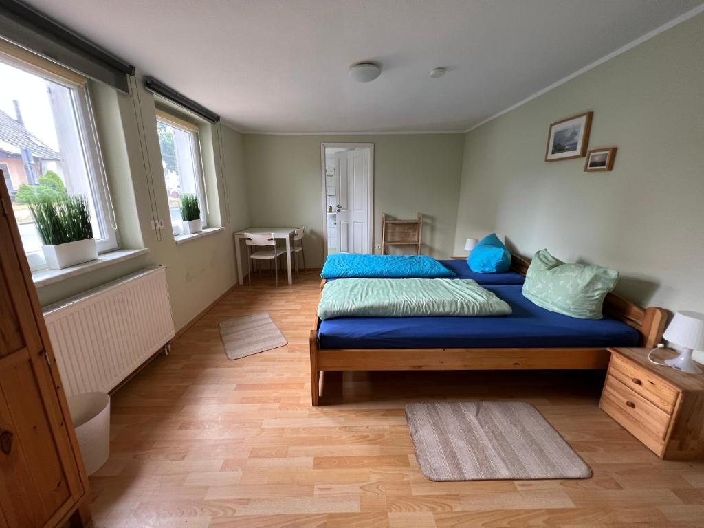 um quarto com uma cama com lençóis azuis e uma mesa em Pension am Elberadweg - Rogätz 