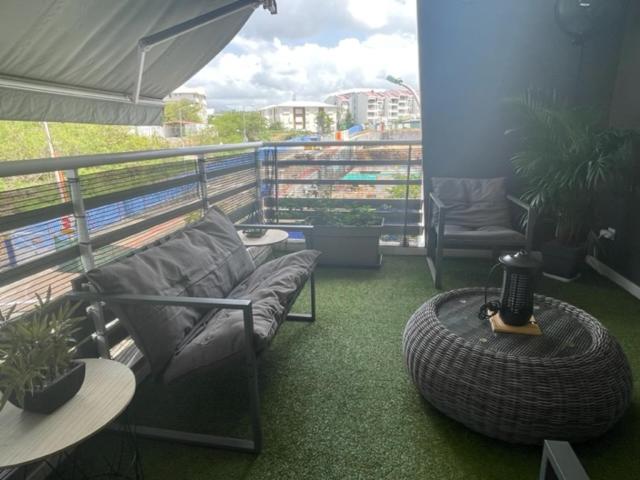 a balcony with a couch and a large tire at Appart Marina étang Z'abricots in Fort-de-France