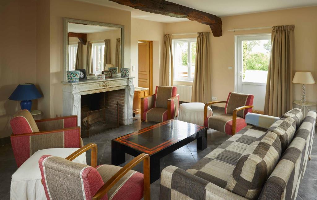 a living room with a couch and chairs and a fireplace at La Maison de Charlotte in Doudeville