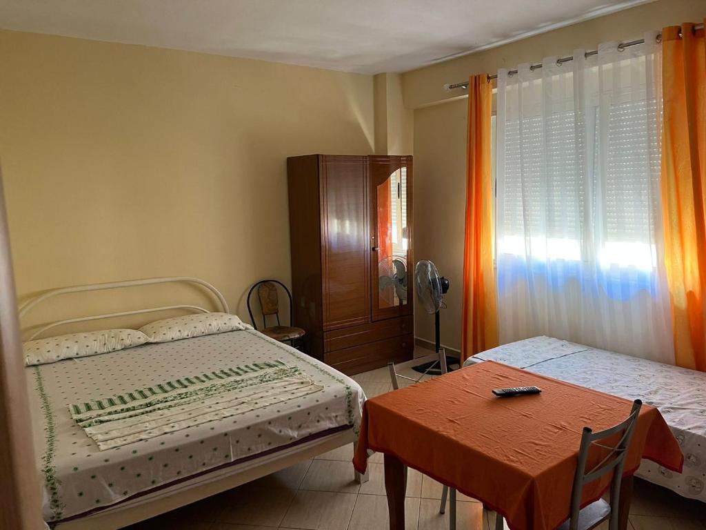 een kleine slaapkamer met een bed en een tafel bij Rexhina Apartments in Durrës