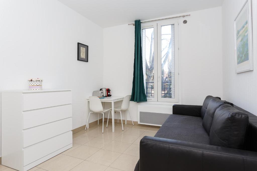 uma sala de estar com um sofá e uma mesa em Jean Jaurès chambre 1ére étage em Aubervilliers