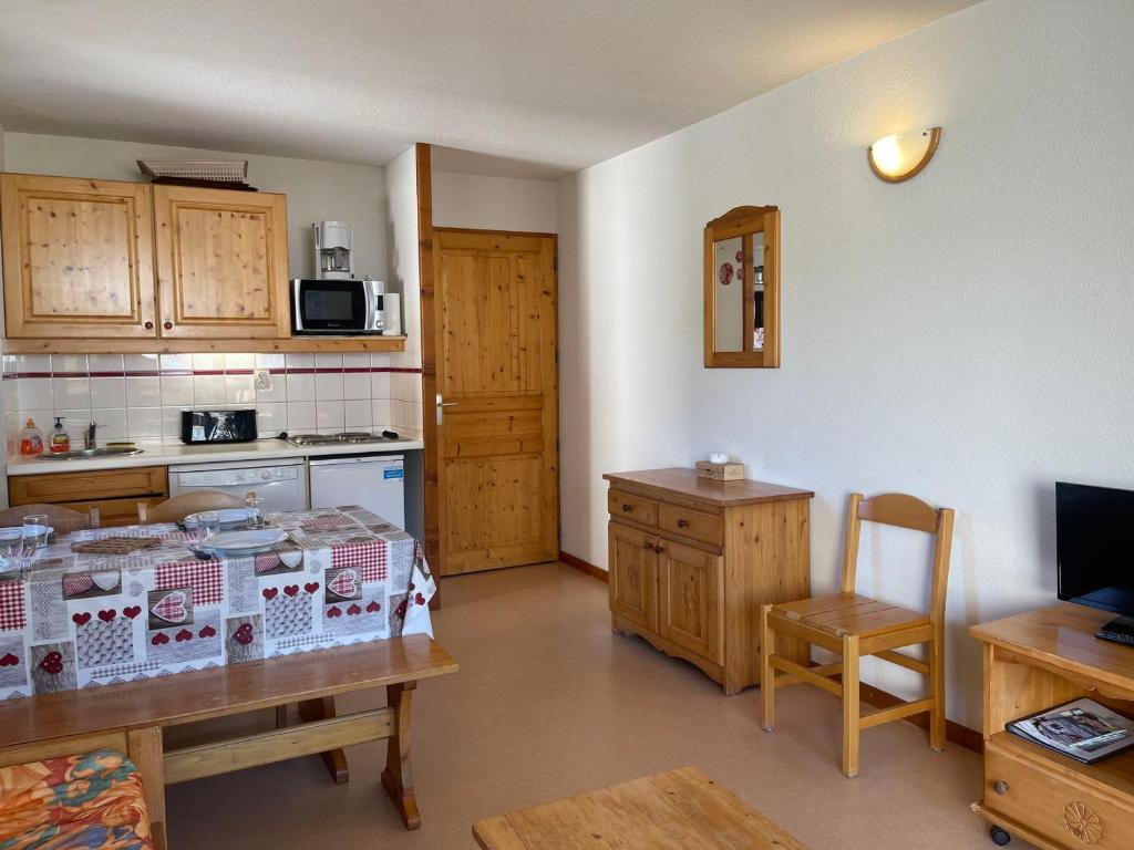 a kitchen with a table and a kitchen with a counter at Appartement Morillon 1100, 2 pièces, 7 personnes - FR-1-624-100 in Morillon