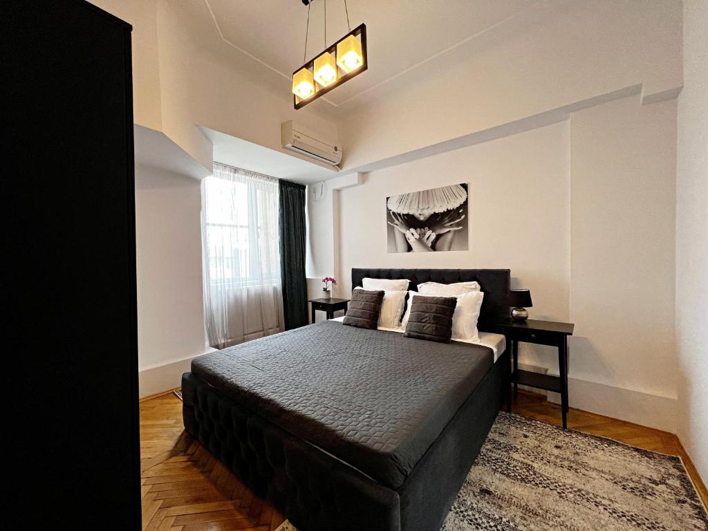 una camera con un letto nero e una finestra di City View - Luxury Apartment - Sanador Victoriei a Bucarest