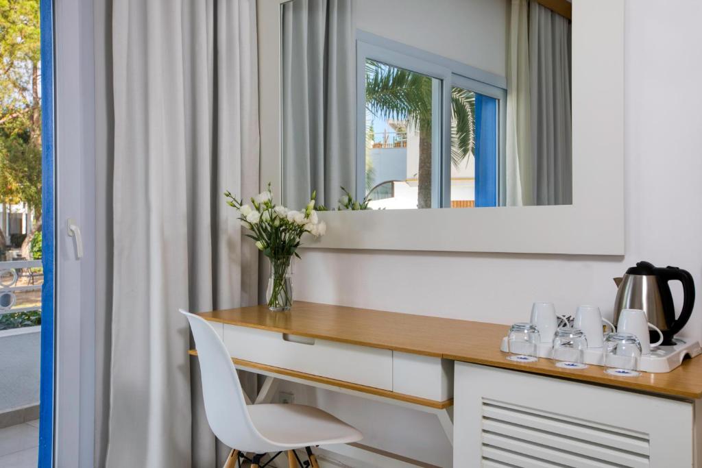 a bathroom with a desk and a mirror at Labranda TMT Bodrum in Bodrum City