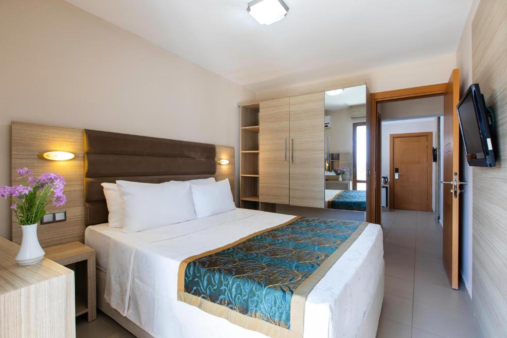 a bedroom with a large bed and a television at Labranda Lebedos Princess - All Inclusive in Seferihisar