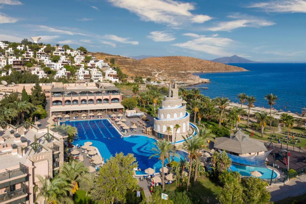 an aerial view of a resort with a pool and the ocean at Kairaba Bodrum Imperial in Akyarlar