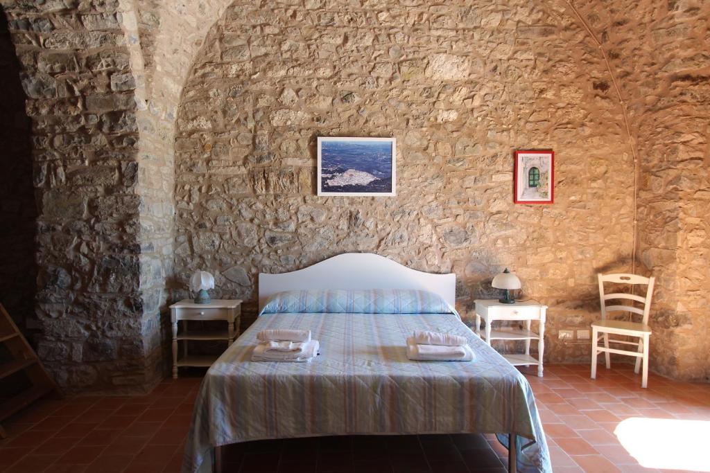 a bedroom with a bed in a stone wall at Dimora Schioppo - Irpinia in Calitri
