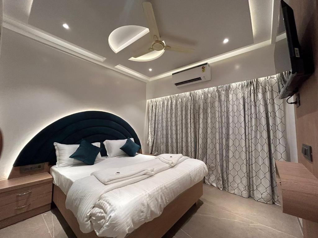 a bedroom with a large bed with a blue headboard at Hotel AR Inn in Thane