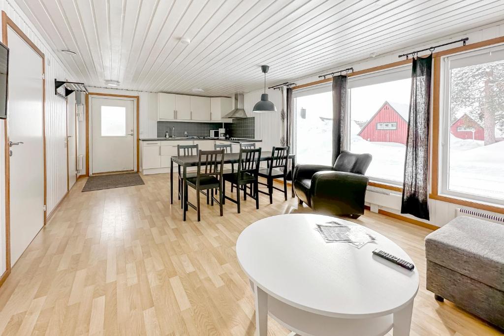 Il comprend une cuisine et un salon avec une table et des chaises. dans l'établissement Kraja, à Arjeplog