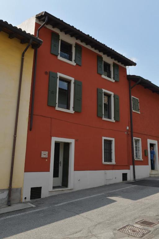 een rood gebouw met groene luiken op een straat bij Civico 43 in Carpenedolo