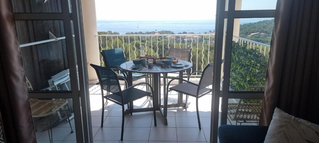 une pièce avec une table et des chaises sur un balcon dans l'établissement Agay Cap Esterel Le Hameau F2 Clim plein sud dernier etage Magnifique vue mer, à Agay