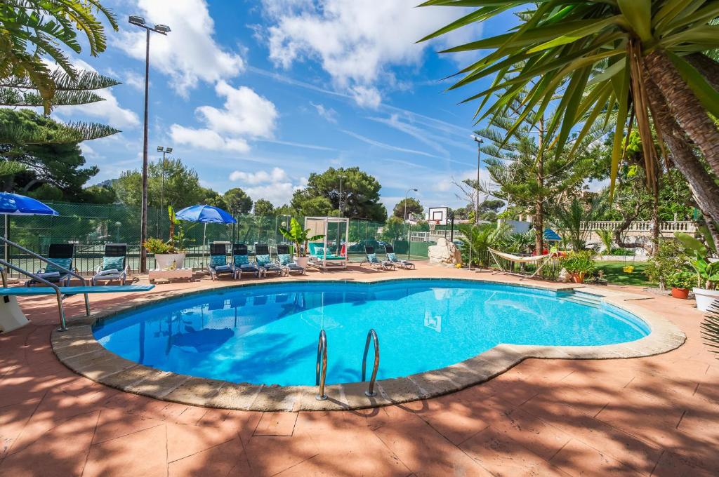 una piscina en un complejo con sillas y sombrillas en Ideal Property Mallorca - Sol de Mallorca 1, en Cala Mesquida