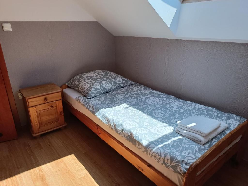 プツクにあるPokoje gościnne Weronikaの小さなベッドルーム(ベッド1台、ナイトスタンド付)
