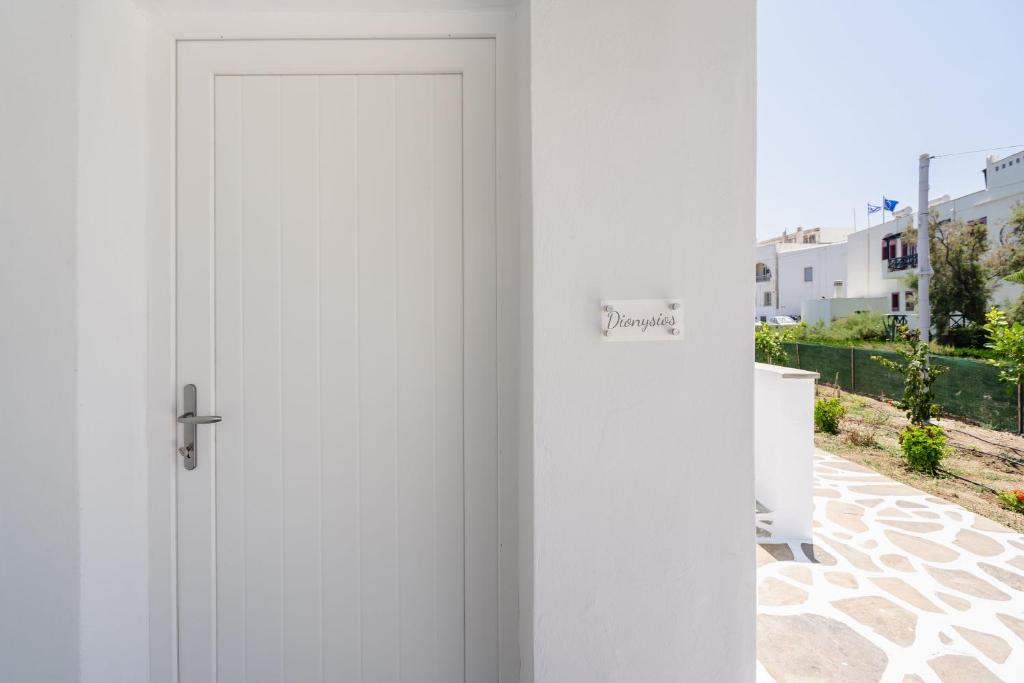 una porta bianca con un cartello che legge la proprietà di Celestial Seaview Apartments-Dionysios a Naxos Chora